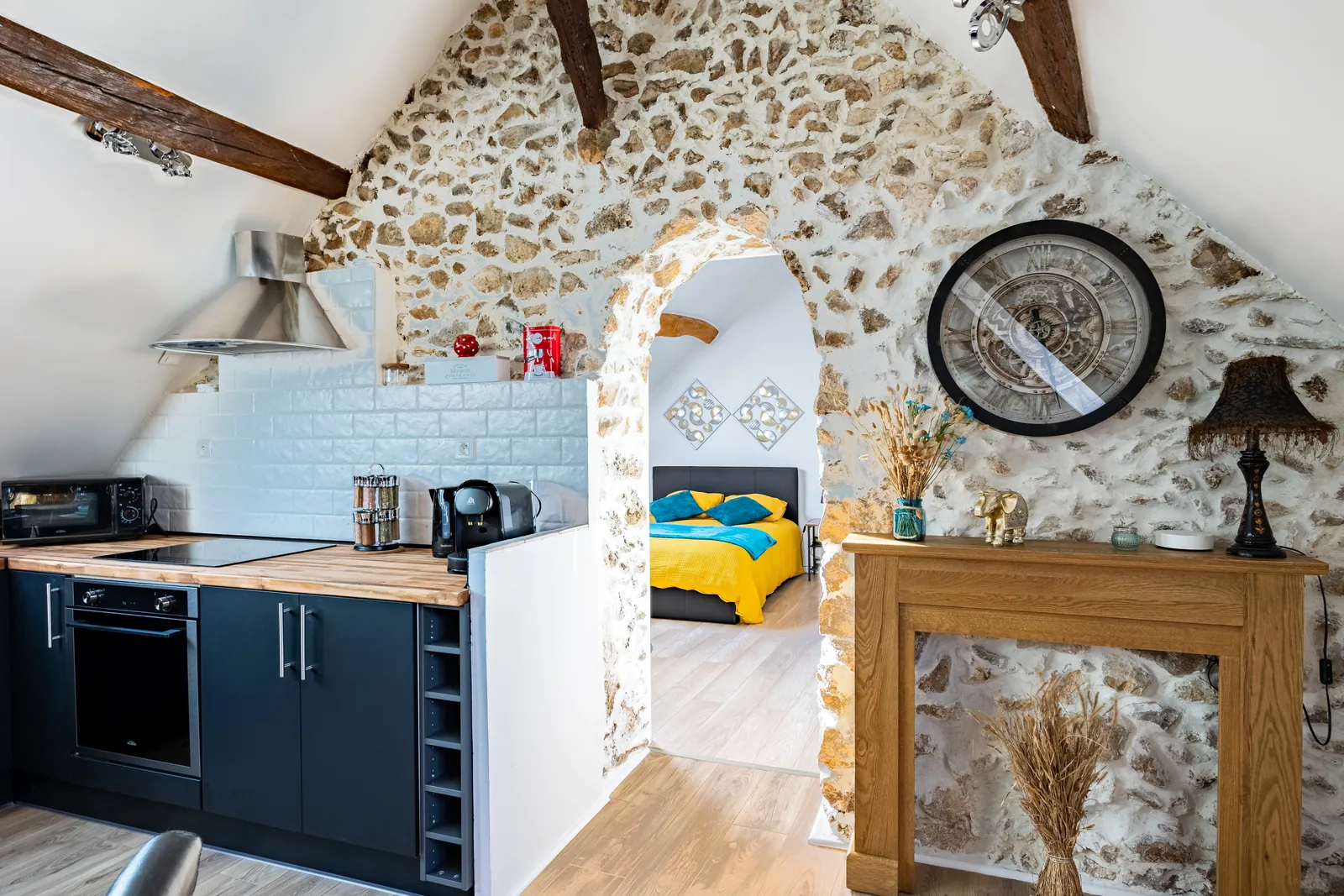 Arche en pierres apparentes ouvrant sur la chambre, cuisine équipée